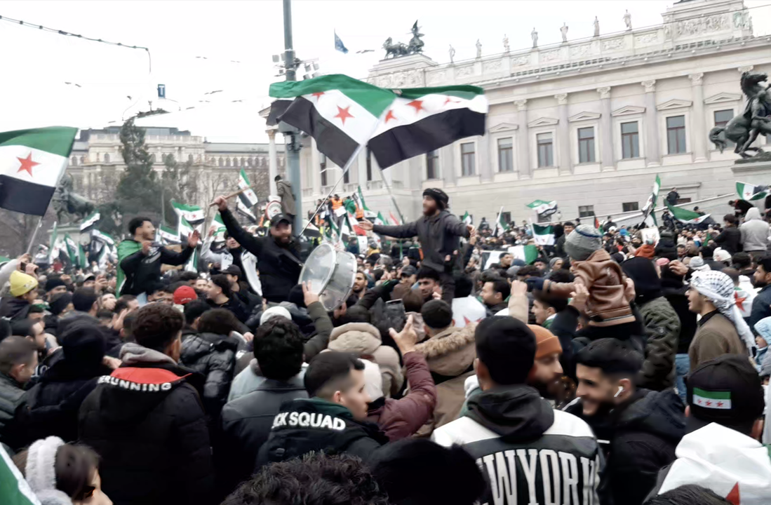 Figure 1. Young men dance to the beat of a drum, holding revolutionary flags during the festive demonstration in Vienna, celebrating the fall of the Assad regime on December 8, 2024 (photo by the author).